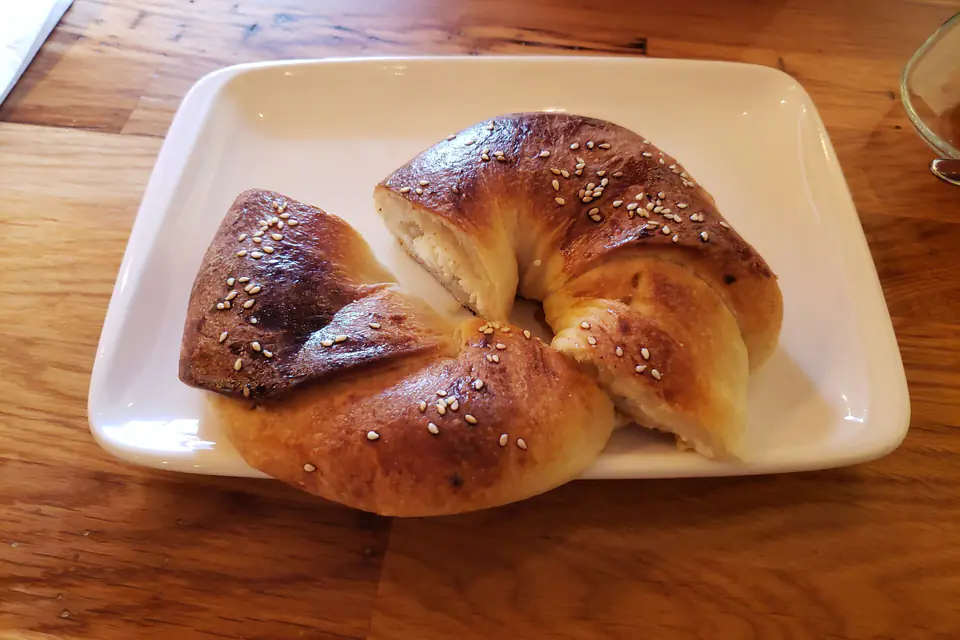 Sesame-topped açma on a white plate