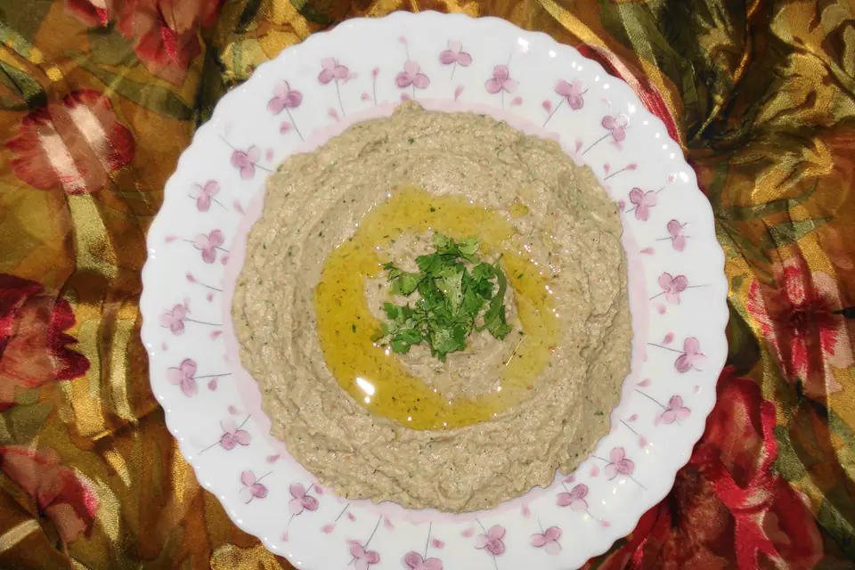 Baba ghanoush on a plate with olive oil and parsley