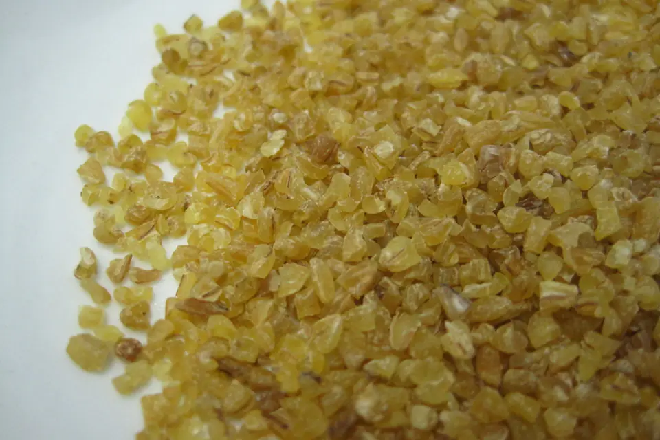 Raw bulgur grains on a white background