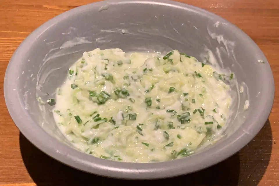 Yogurt with grated cucumber and herbs in a bowl