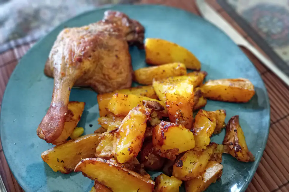Baked chicken leg with roasted potatoes on a plate