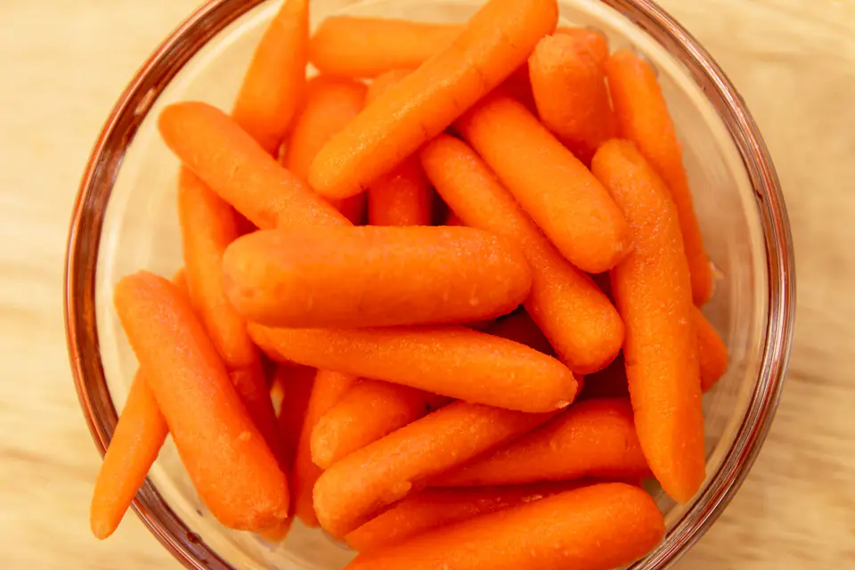 Raw carrots in a glass bowl