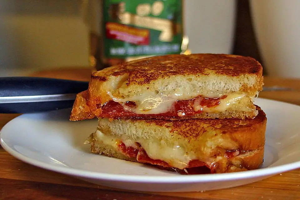 A mixed toastie cut in half on a plate