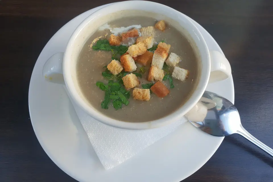 Mushroom soup with croutons and parsley in a cup