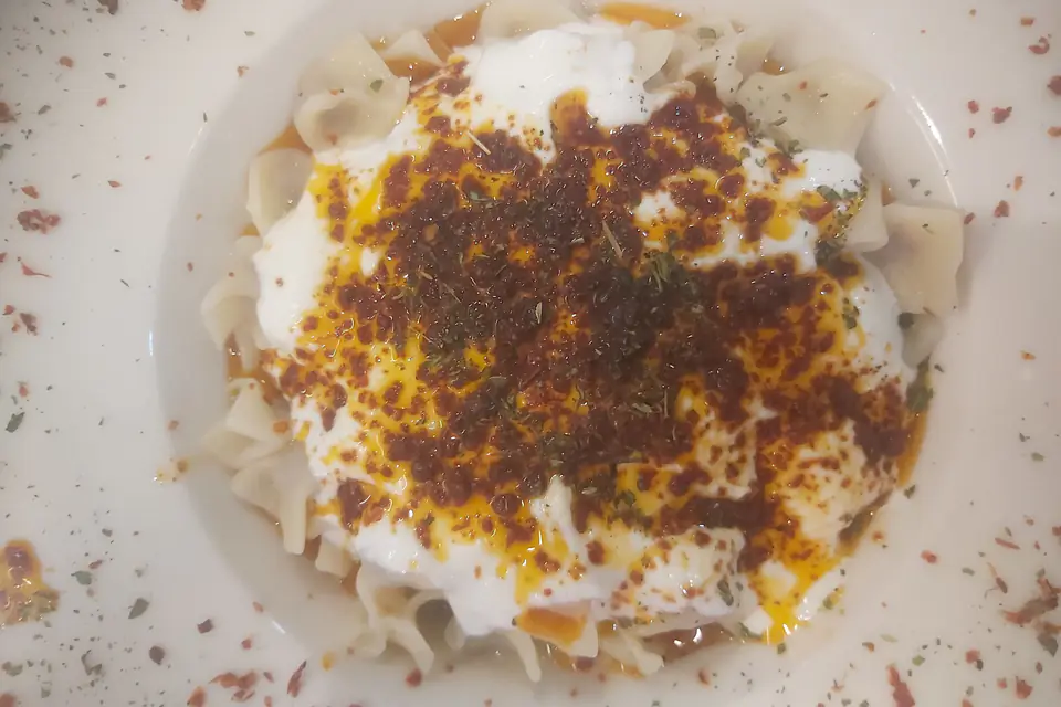 Mantı with yogurt and red pepper butter on a plate