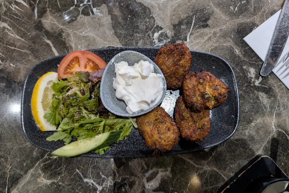 Mücver served with yogurt, lemon and greens