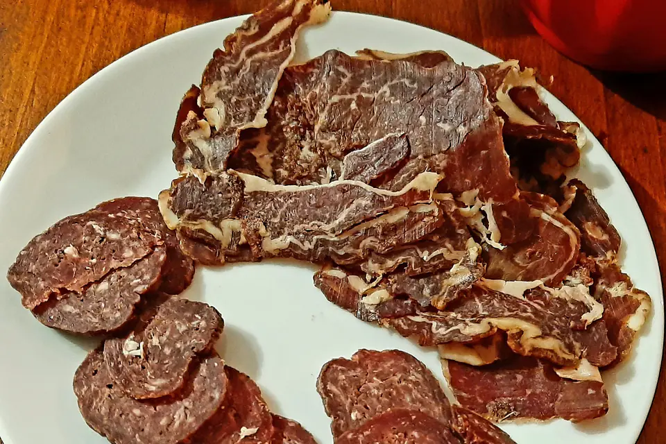 Thinly sliced pastırma and sucuk on a plate