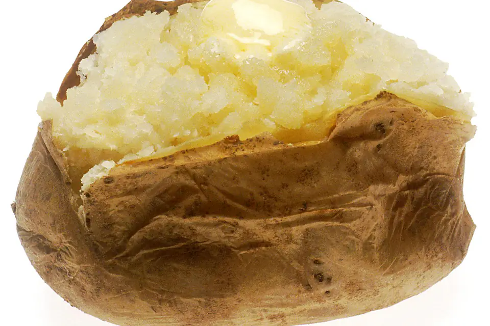 A baked potato in its skin with butter