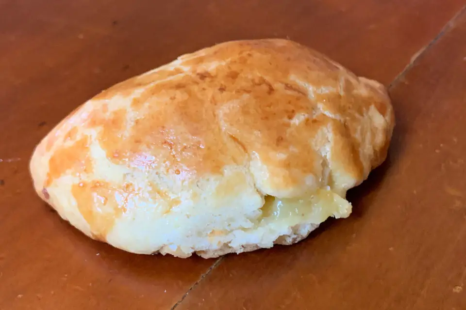 A baked poğaça on a wooden table