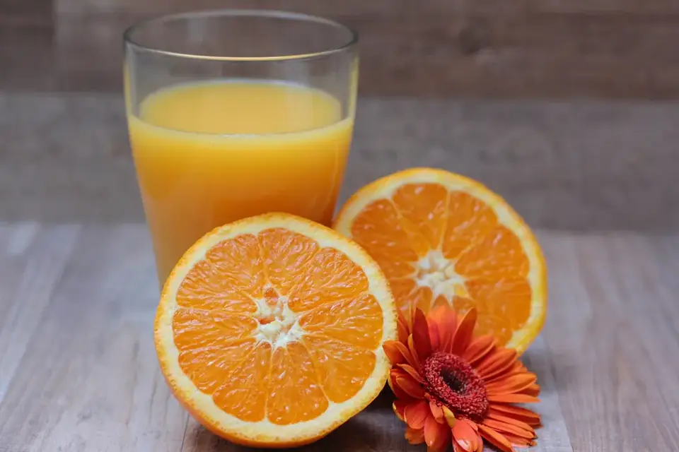 Orange juice in a glass with halved oranges