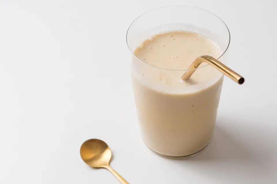 A milk shake with a straw in a glass