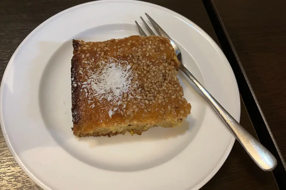 A slice of revani with a fork on a plate