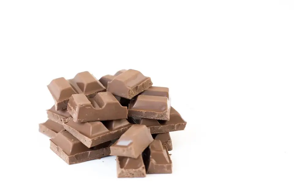 Broken pieces of milk chocolate on a white background