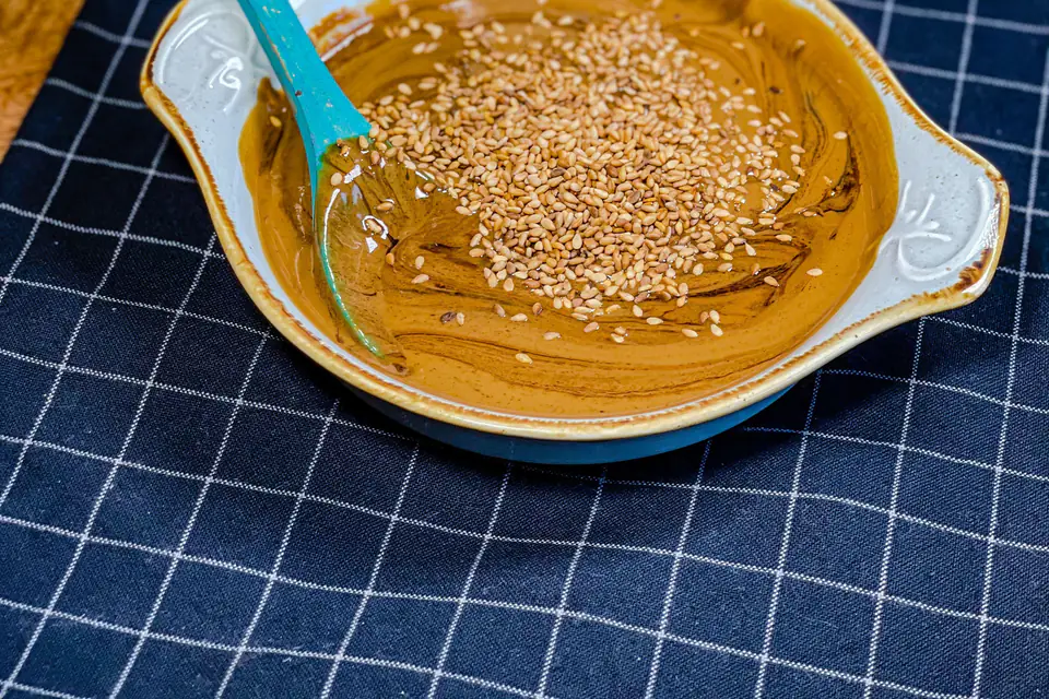 Tahini and grape molasses with sesame seeds in a bowl