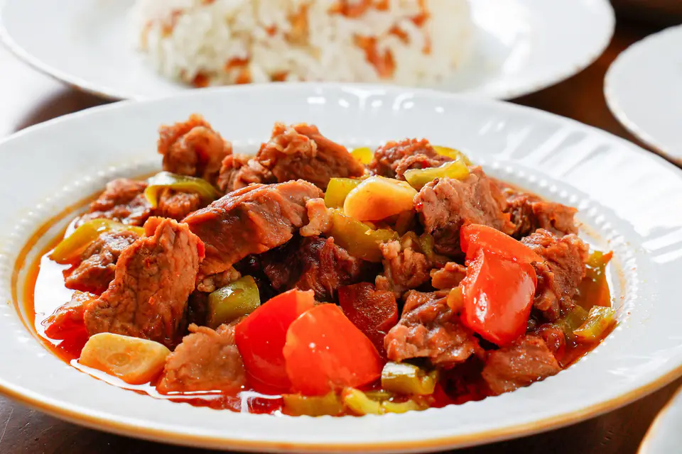 Tas kebab with peppers and tomatoes on a plate