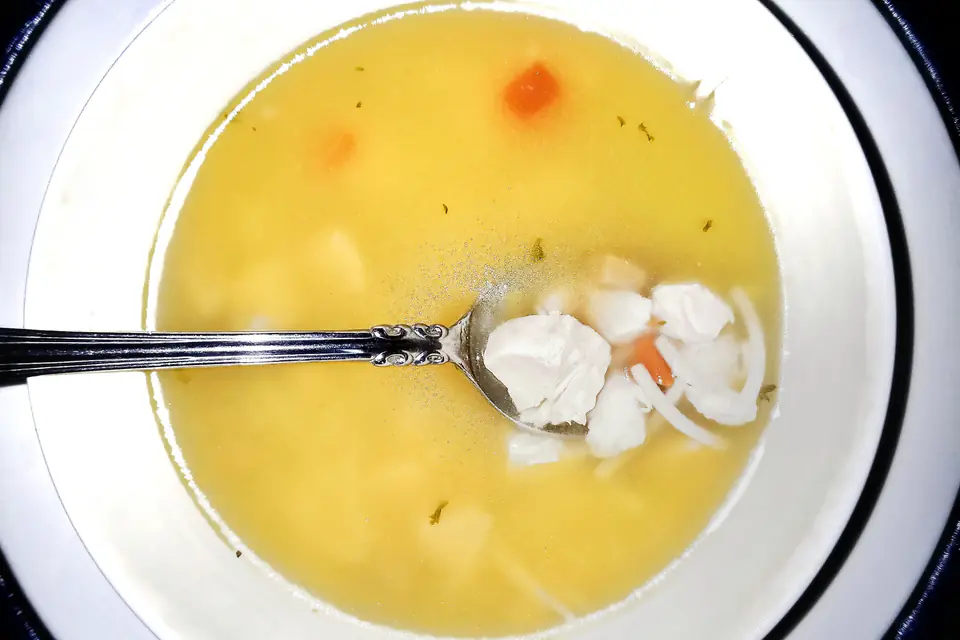 Chicken soup with chicken pieces and carrots in a bowl