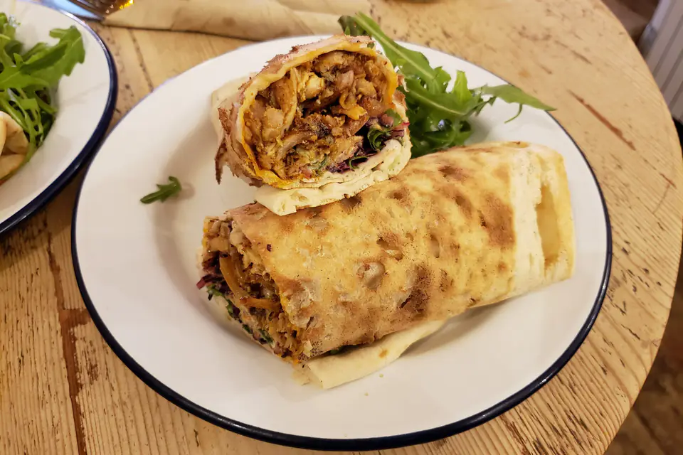 A chicken döner wrap cut in half on a plate