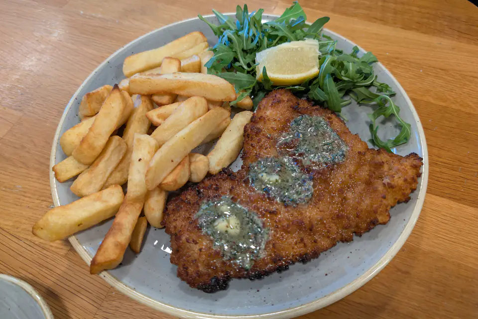 Chicken schnitzel with French fries and arugula