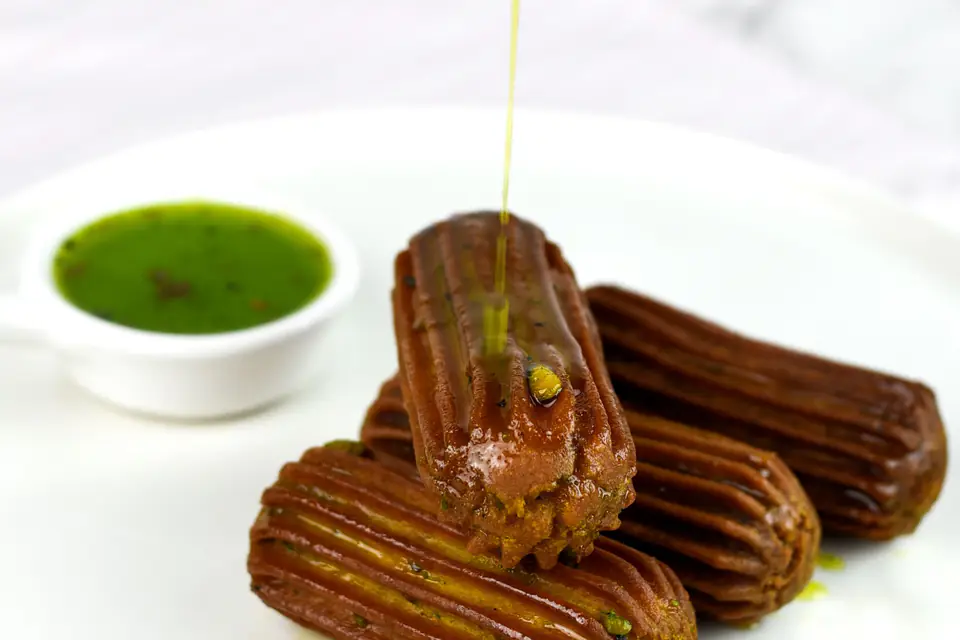 Syrupy tulumba with pistachio sauce on a plate